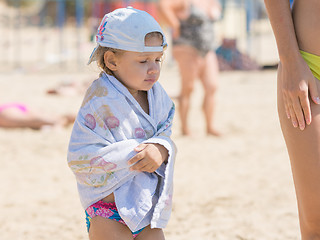 Image showing The little girl is very cold bathing in the sea and basking wrapped in a towel