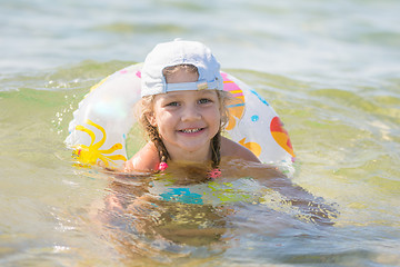 Image showing Four-year girl floats with a circle in the sea water