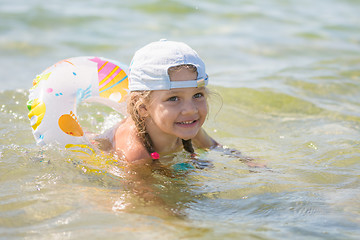 Image showing Happy four-year girl floats with a circle in the sea water