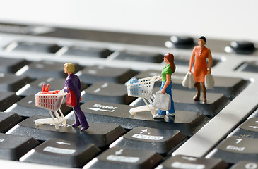 Image showing Miniature shoppers  with shopping cart 