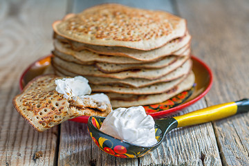 Image showing Pancakes from wholemeal flour and spoon sour cream.