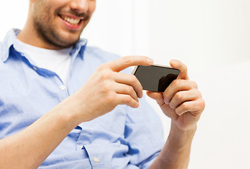 Image showing close up of man with smartphone at home
