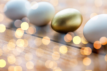 Image showing close up of golden and white easter eggs on wood