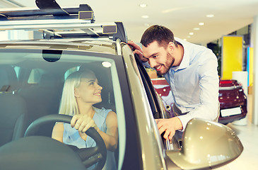 Image showing happy couple buying car in auto show or salon