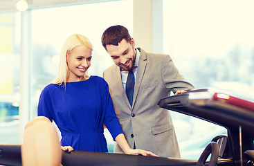 Image showing happy couple buying car in auto show or salon