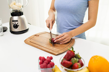 Image showing close up of woman chopping strawberry at home