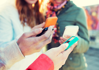 Image showing close up of friends with smartphones outdoors