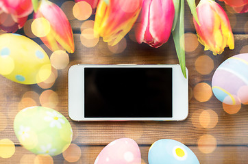 Image showing close up of easter eggs, flowers and smartphone