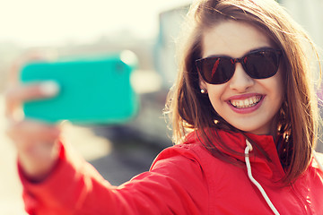 Image showing smiling young woman taking selfie with smartphone