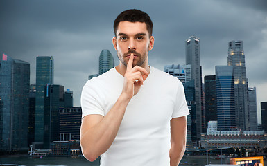 Image showing man making hush sign over evening singapore city