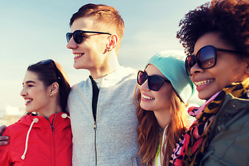 Image showing happy teenage friends in shades hugging outdoors