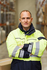 Image showing man in coveralls with box at warehouse