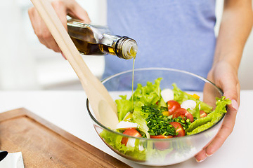 Image showing close up of woman cooking vegetable salad at home