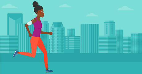 Image showing Woman jogging with earphones and smartphone.