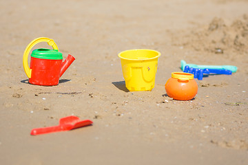 Image showing Kids sand toys lie on the beach seaside