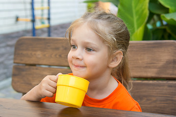Image showing Four-year girl smiling holding a glass of juice