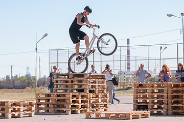 Image showing Cyclist tracer jumping on a wooden pallet in front of audience