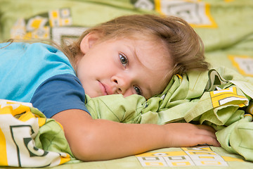 Image showing Girl lying on the bed and looking to the right