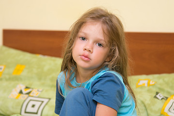 Image showing Five-year girl waking up sleepy sitting on a bed