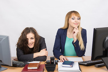 Image showing The situation in the office - one girl crazy looks in the picture, her colleague looking at monitor