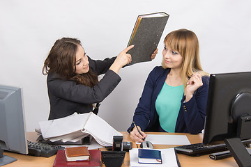 Image showing The girl in the office of a colleague that threatens to hit its folder