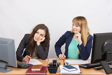 Image showing The situation in the office - one girl is very upset, others are pretty straightens things on your desktop