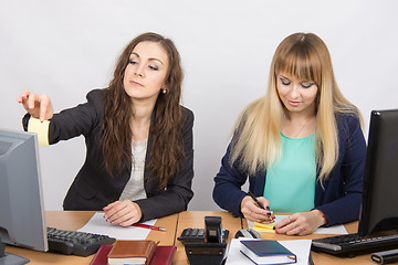 Image showing The office staff write reminder notes on a small square