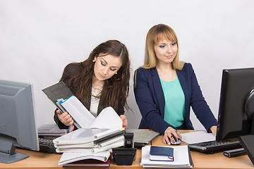 Image showing Female colleagues in the office, one works with paper documents, the second computer with electronic