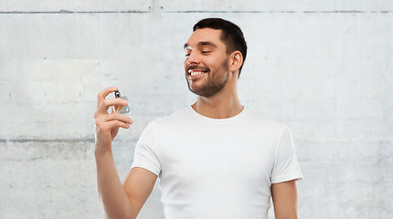 Image showing smiling man with male perfume over gray background