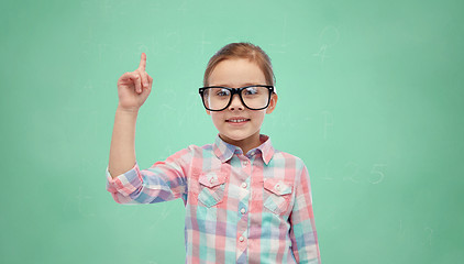 Image showing girl in glasses pointing finger up over green