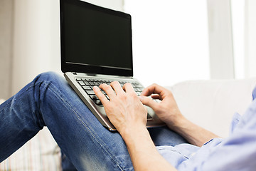 Image showing close up of man typing on laptop computer at home