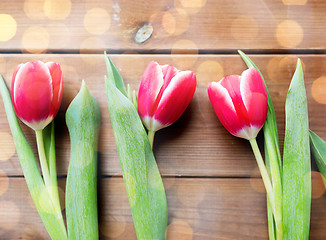 Image showing close up of red tulip flowers on wooden table