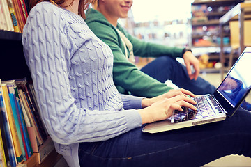 Image showing close up of happy students with laptop in library