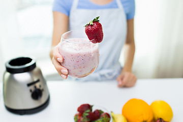 Image showing close up of woman holding glass with fruit shake