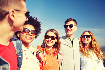 Image showing happy teenage friends in shades talking on street