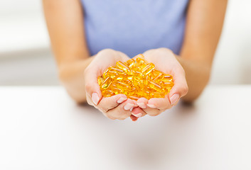 Image showing close up of woman hands holding pills or capsules