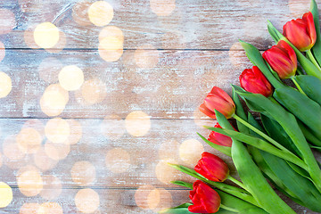 Image showing close up of red tulips on wooden background