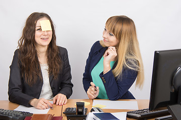 Image showing office employee a note taped to the forehead of his colleague