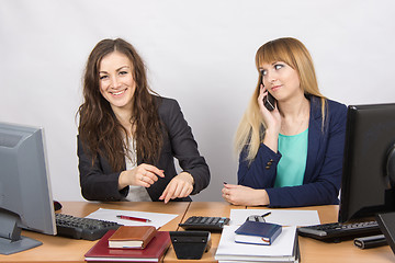 Image showing The situation in the office - an employee of a colleague who laughs on the phone