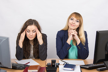 Image showing The situation in the office - from one girl really a headache, the other looks happy in the picture