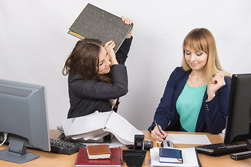 Image showing Girl in office with folder anger trying to hit his colleague