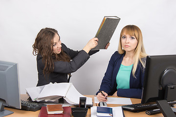Image showing The girl in the office has a head of his colleague big folder