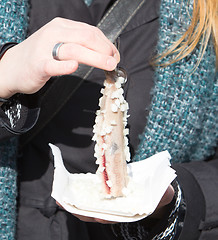 Image showing Dutch woman is eating typical raw herring