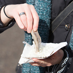 Image showing Dutch woman is eating typical raw herring