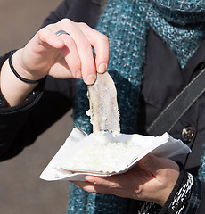 Image showing Dutch woman is eating typical raw herring