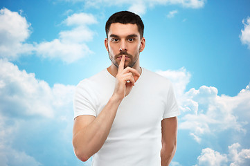 Image showing young man making hush sign over blue sky