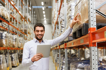 Image showing happy businessman with tablet pc at warehouse