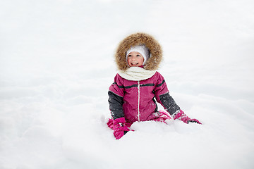 Image showing happy little kid or girl in winter clothes on snow