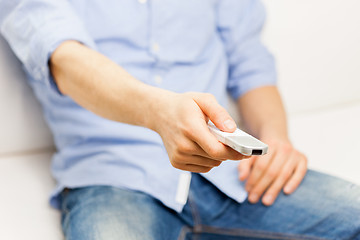 Image showing close up of man with tv remote control at home