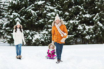 Image showing happy family with sled walking in winter forest
